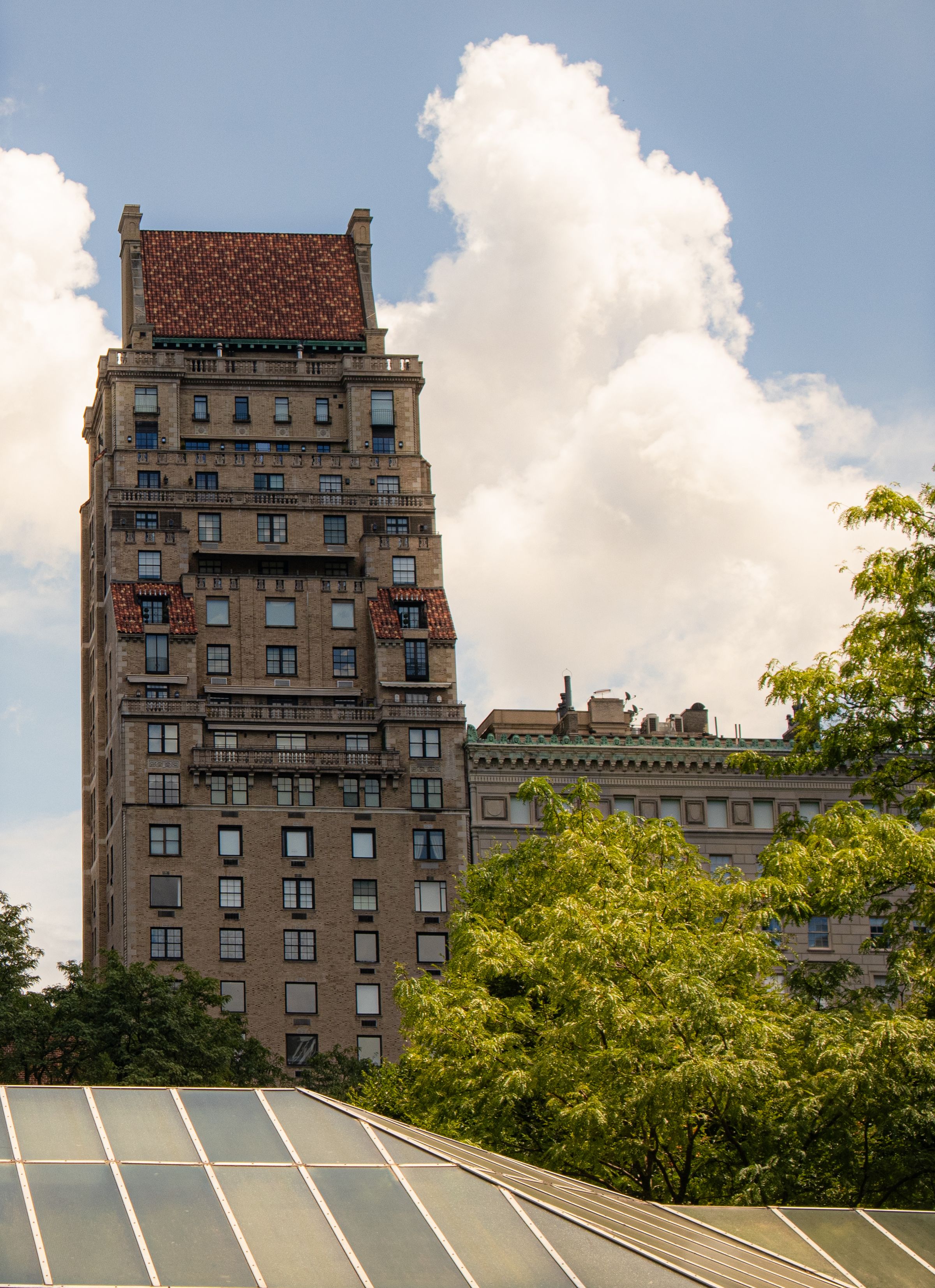 New York residential building facade rising above a tree-lined block